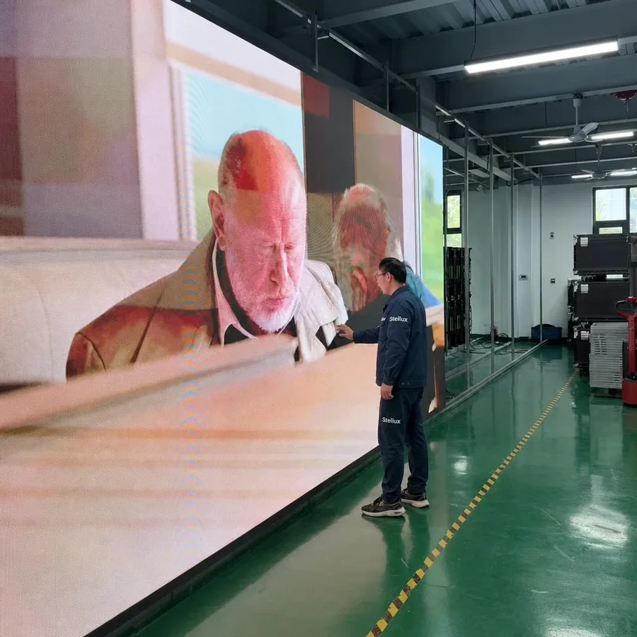 Stellux engineer inspecting a full-wall indoor LED display during colour and uniformity testing